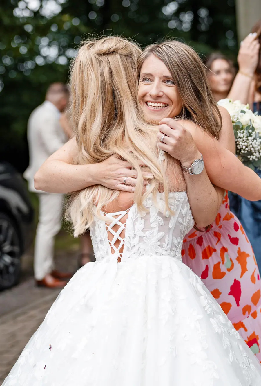 Braut Nicole umarmt Hochzeitssängerin Janet nach einer kirchlichen Hochzeit in Lotte Wersen